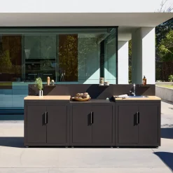 Cozinha exterior com 3 módulos em aço e decoração em madeira