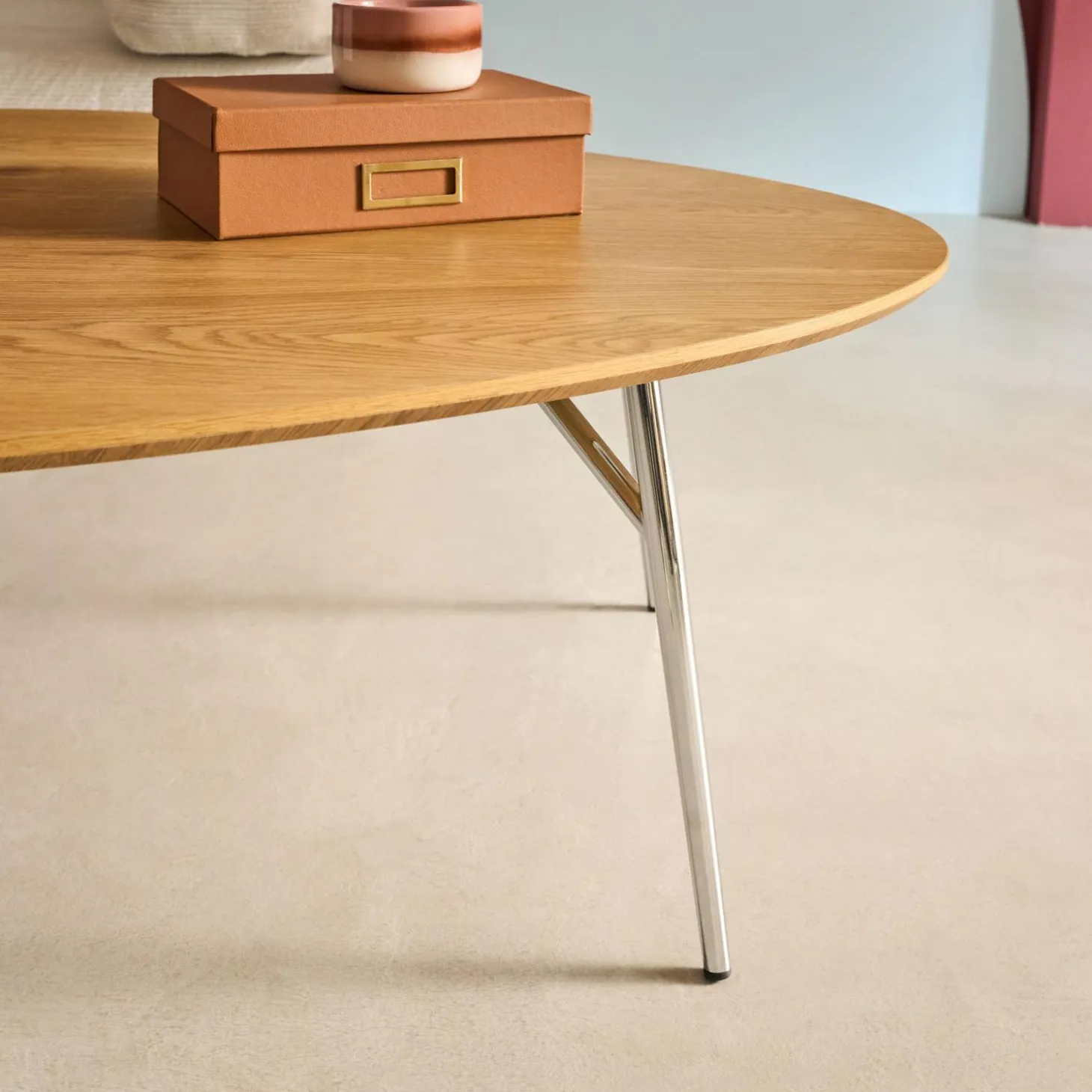 Mesa de centro triangular com pernas cromadas e efeito de madeira