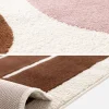 Tapete de interior com padrão gráfico rosa e castanho
